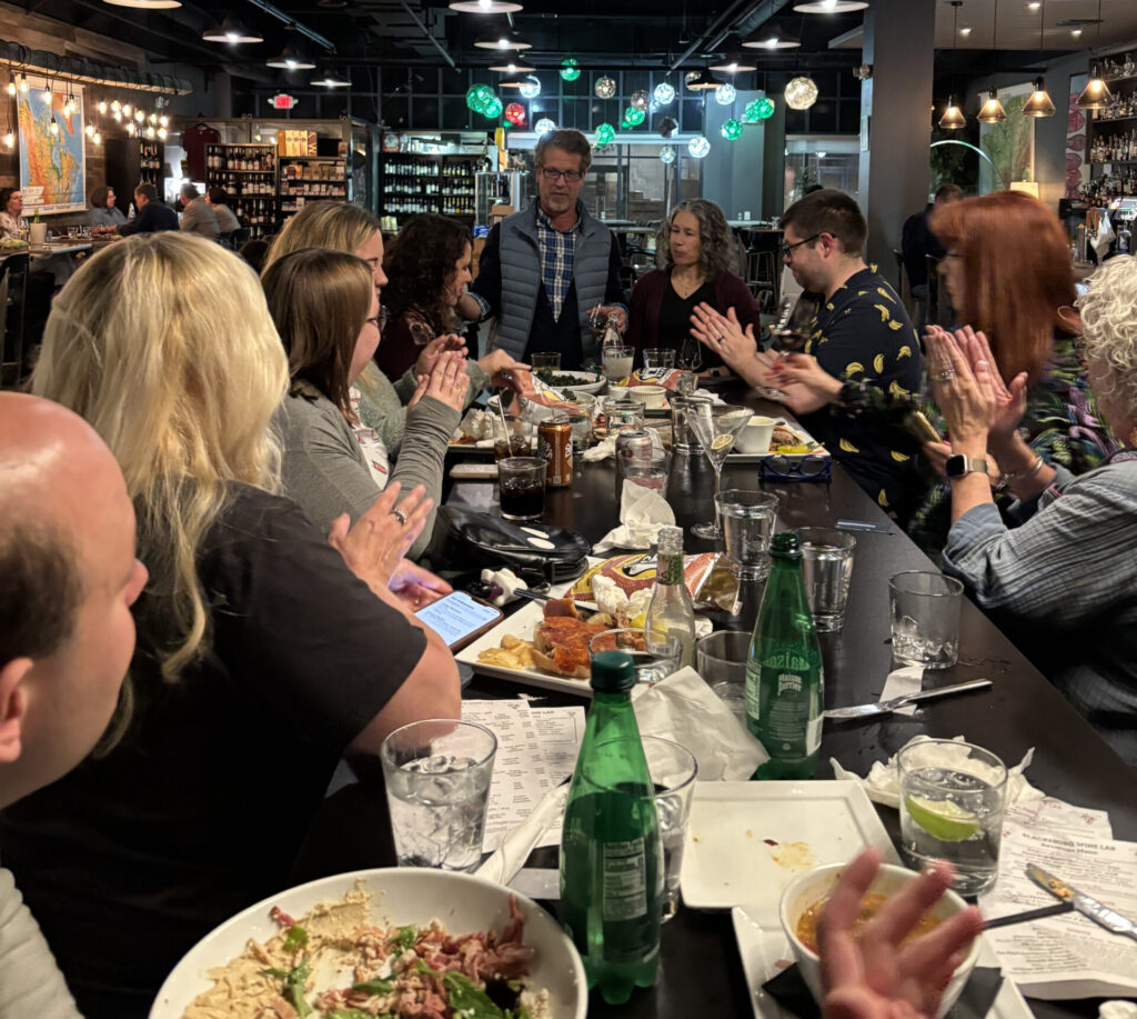 A table full of travel journalists sit down for a meal at the Blacksburg Wine Lab.