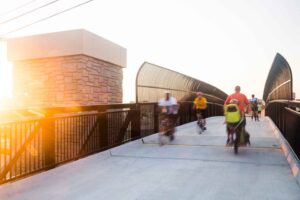People riding bikes over a bridge on the Huckleberry Trail